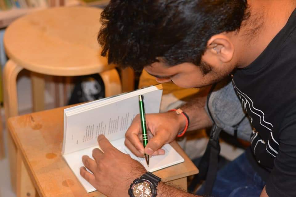 Migrant-Poet-signing-books-at-Call-and-Response_.jpg